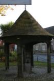At the centre of Woolpit, triangular crossroads meet at the village pump, housed under a conical pavilion erected in 1897 to commemorate Queen Victoria's Diamond Jubilee. Each of its four wooden posts is decorated with a carving of a former Queen of England.<br /><br />Surrounding the pump are local shops, pubs, and the Woolpit Bygones Museum.<br />